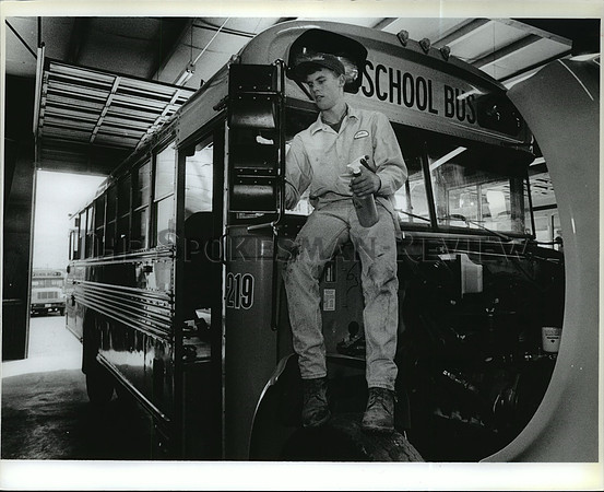 1993 Press Photo Justin Criddle shines up a Mayflower school bus