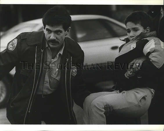 1990 Press Photo Paramedic Kevin Uphus helps lift an injured boy into ambulance.
