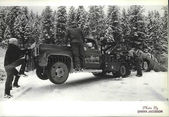 1987 Press Photo People Stand on Tow Truck to pull Snow Stranded Pickup Truck